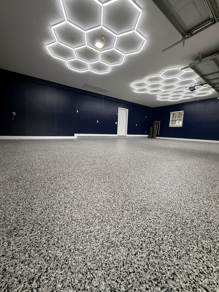 Close view of flake flooring beneath hexagon garage lights